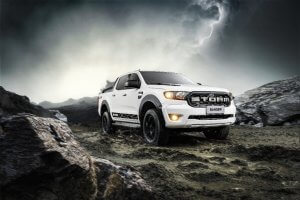 Ford Ranger Storm branca estacionada em uma terreno de pedras com a simulação de um relâmpago no céu ao fundo