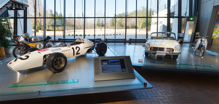 Museu Da Honda tem modelo de corrida baratinha à esquerda e carro dos anos 1960 à direita logo na entrada