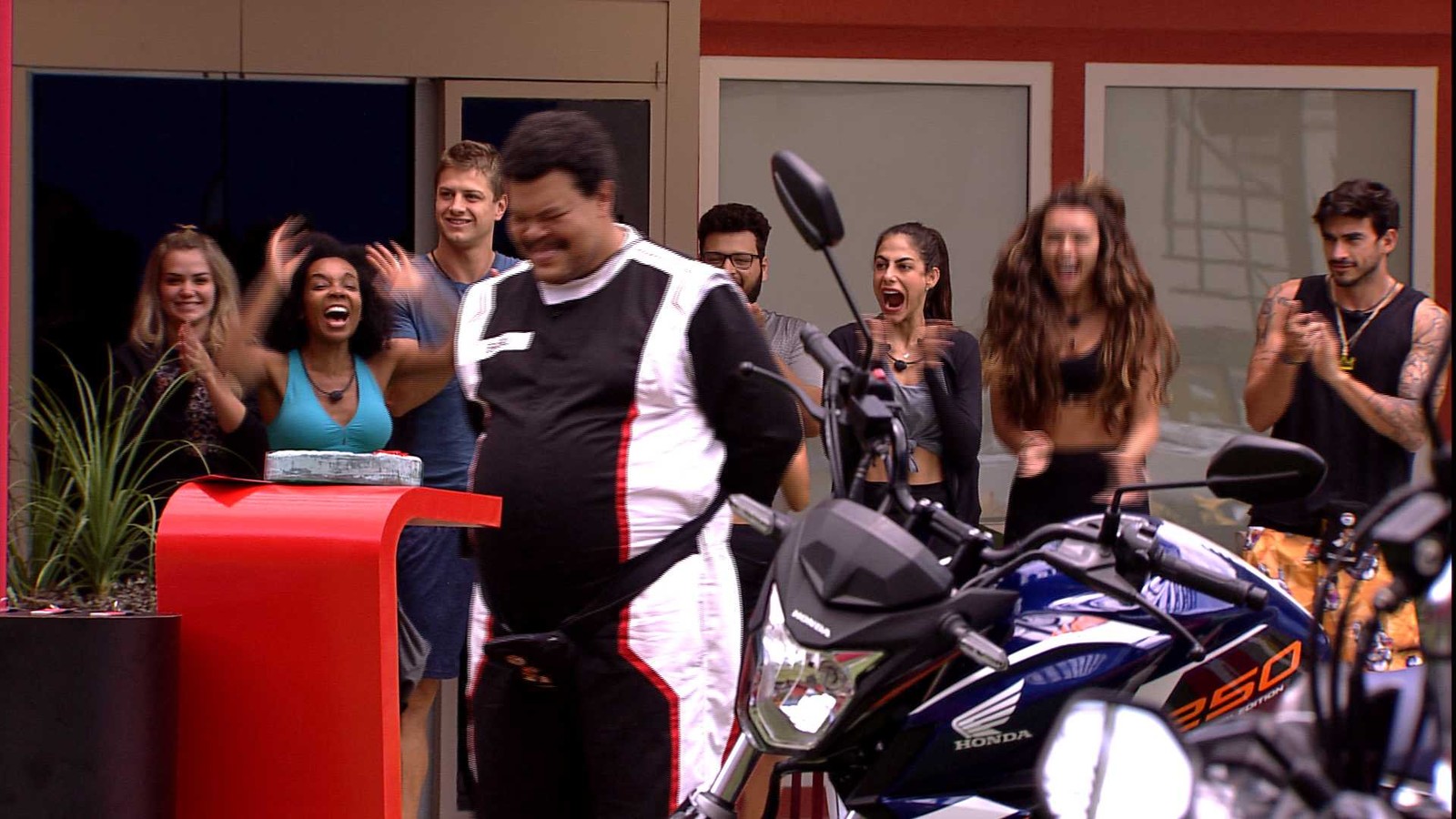 Participantes do programa Big Brother Brasil ao lado da moto Honda Cb 250 Twister