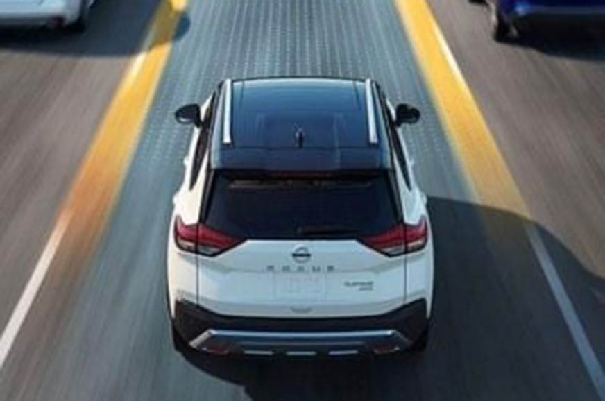 Nissan X Trail de traseuira e do alto em movimento na estrada