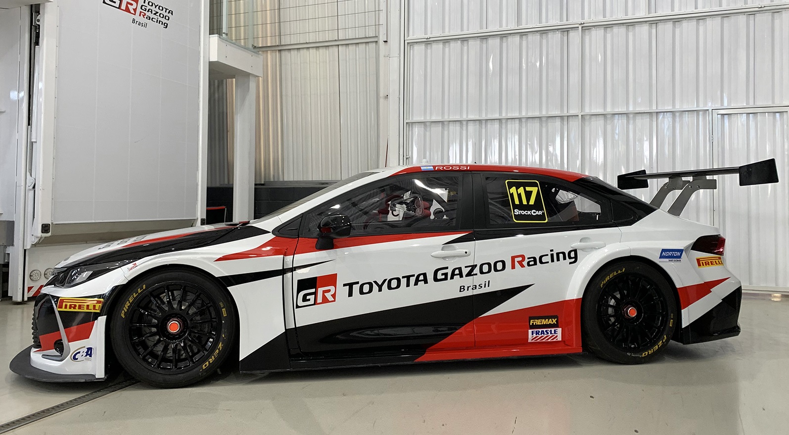 Carro Toyota Gazoo Racing Stock Car 2020 estacionado em uma garagem com grafismos pretos e vermelhos