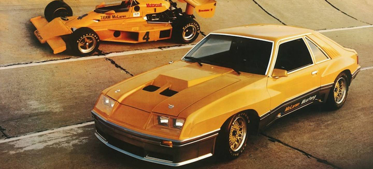 Ford Mustang Mclaren M81 amarelo ao lado de um F1 amarelo da McLaren