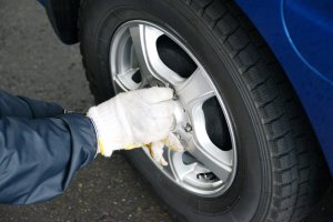 Homem aparafusa roda de pneu