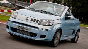 Fiat Uno Cabrio conversível azul calro em movimento na rua e com a capota aberta