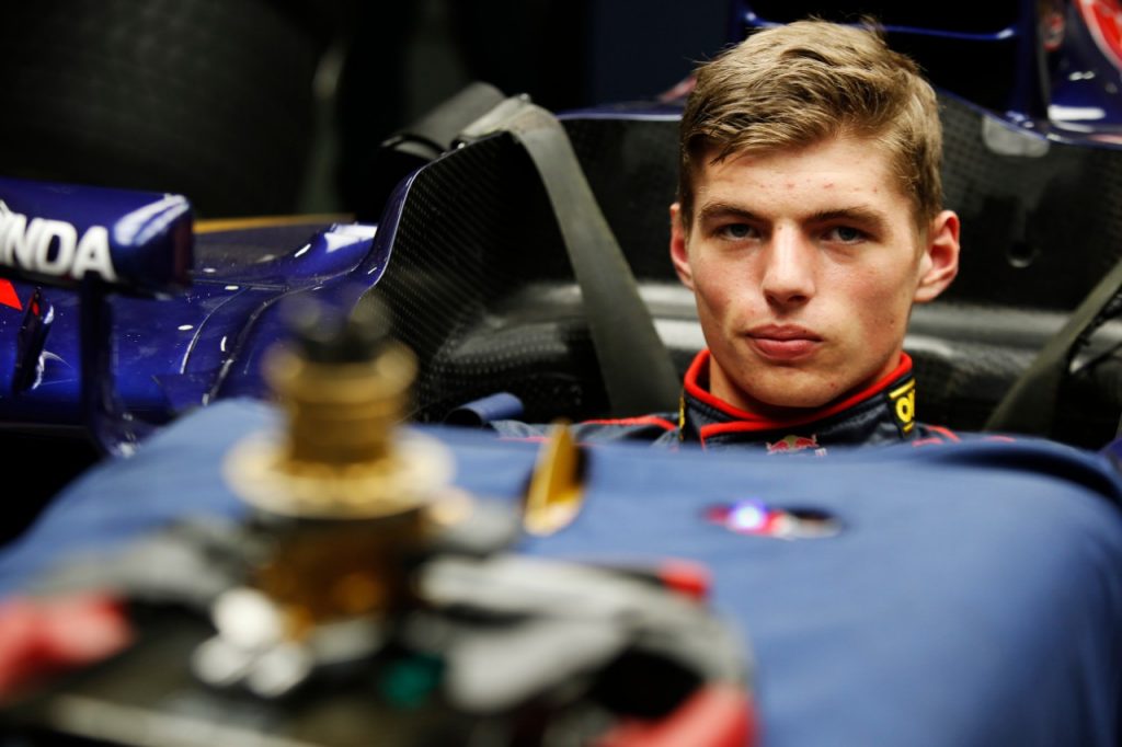 Max Verstappen sentado no cockpit de sua red buill com um volante destacado pousado sobre o carro e desfocado à frente