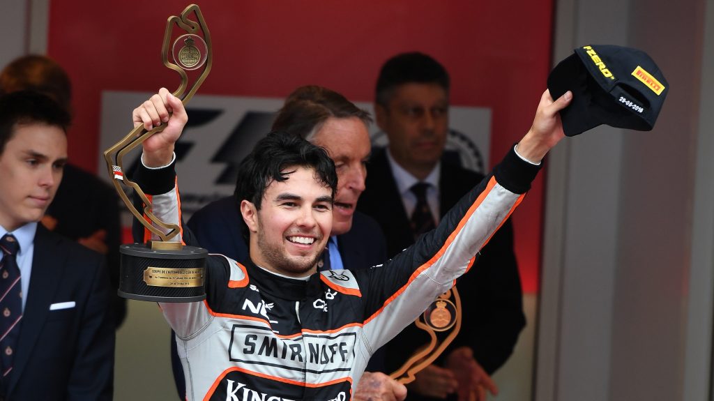 Sergio Perez ergue os braços e uma taça após o pódio