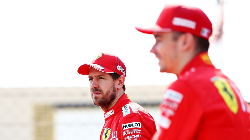 Sebastian Vettel com boné e jaqueta da Ferrari com olhar distante
