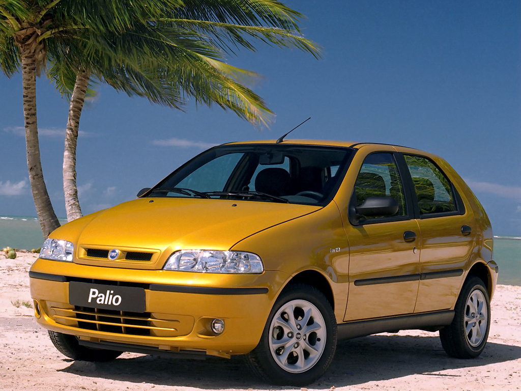 Fiat Palio amarelo estacionado na rua com céu azul ao fundo