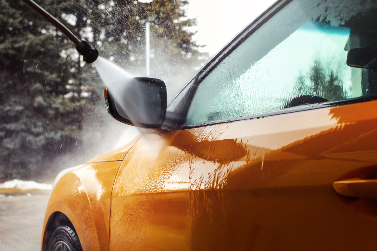 Detail On Dark Yellow Car Front Mirror Being Washed With Jet Water Stream In Carwash.