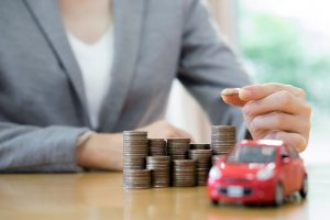 Businesswoman A Toy Car And A Stack Of Coins