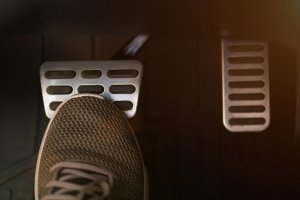pedal de freio em destaque com homem pisando levemente