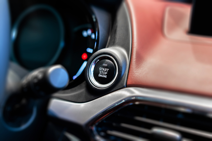 Sistema start stop de um carro em destaque com restante do painel ao fundo desfocado