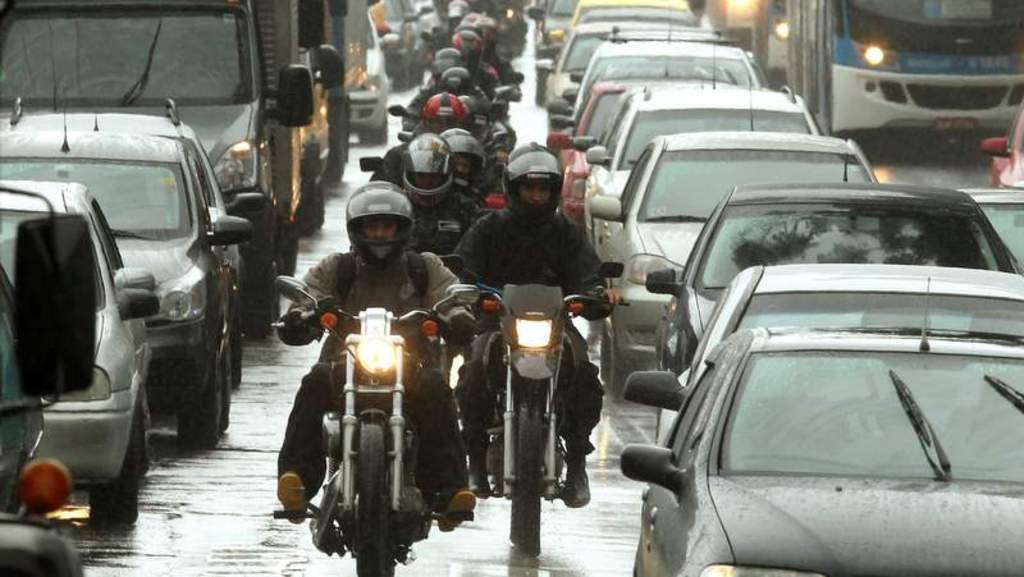 Motorcycle Couriers Cruise Along The Dotted Line Separating Lanes In Sao Paulo