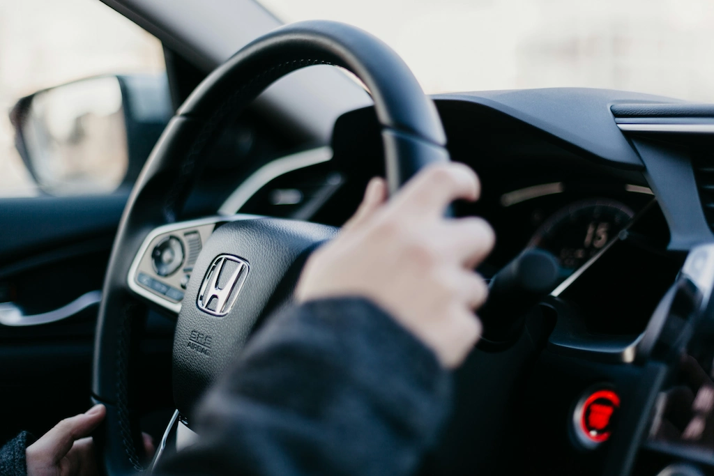 Mão no volante de um carro novo da Honda comprado na Webmotors