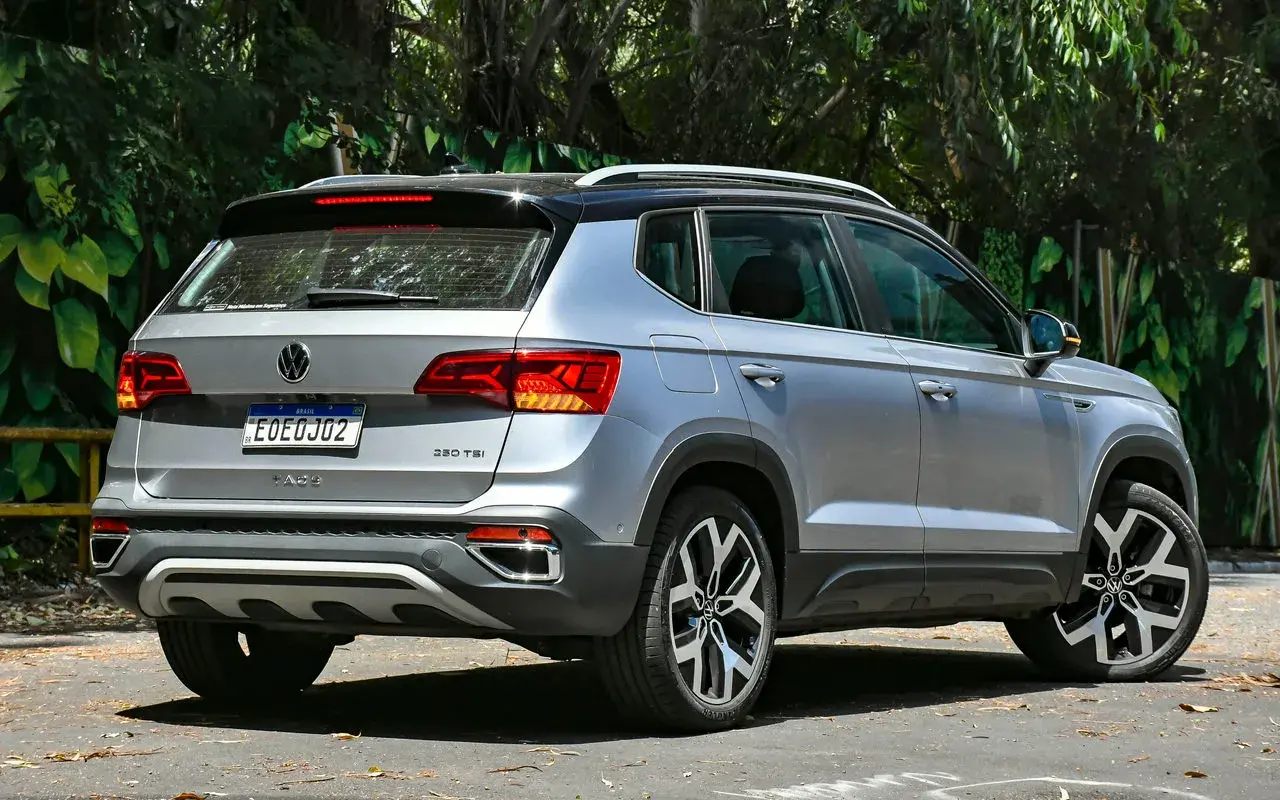 Volkswagen Taos 2025 prata com teto preto posicionado de 3/4 de traseira