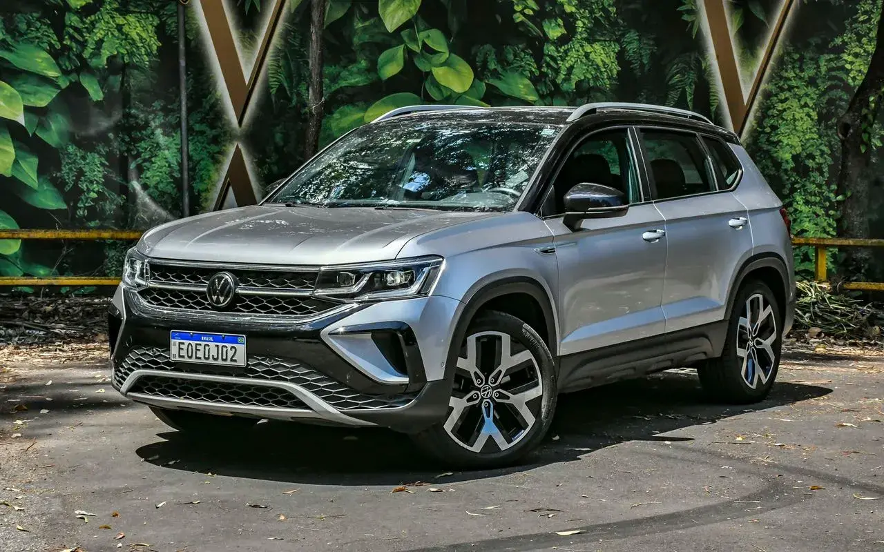 Volkswagen Taos 2025 prata com teto preto posicionado em 3/4 de frente
